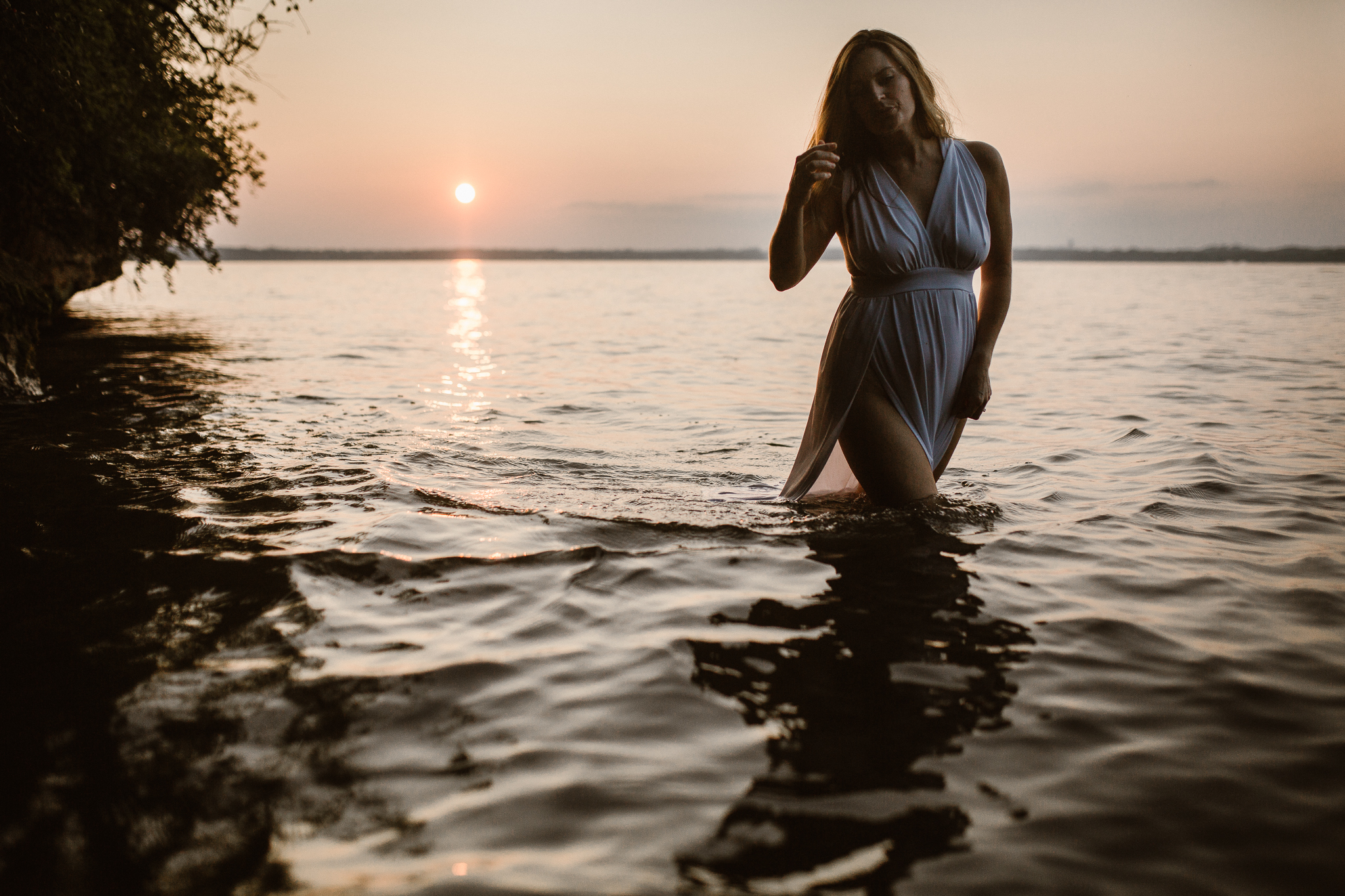 Captivating woman in an intimate lake session during a summer sunset.